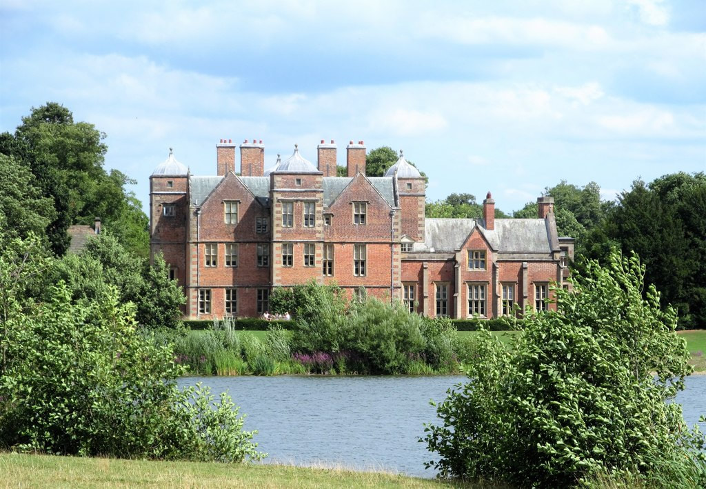 Picture  Kiplin Hall taken by George Hatton.  Image shows Kiplin Hall west front Seen across a corner of the lake, the west front of the hall shows the original, almost square building of circa 1625 with a tower at the mid point of each façade. To the right is the extension of the 1820's which was added by Lord Tyrconnel to make the building into more of a comfortable country house.
